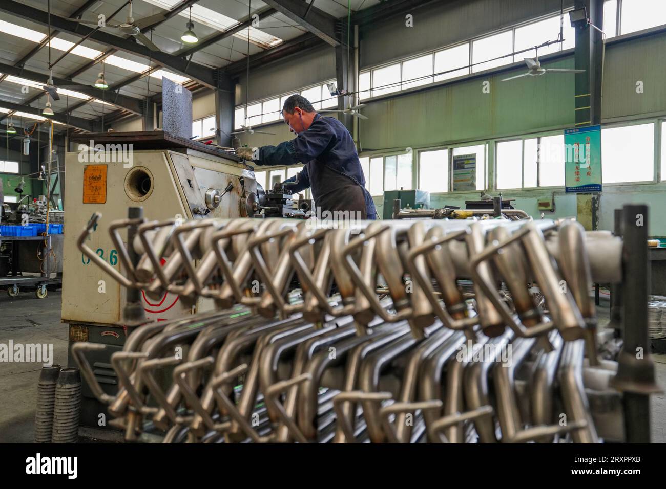 Comté de Luannan, Chine - 20 avril 2023 : les travailleurs utilisent des machines-outils pour traiter les composants de voiturettes de golf. Banque D'Images