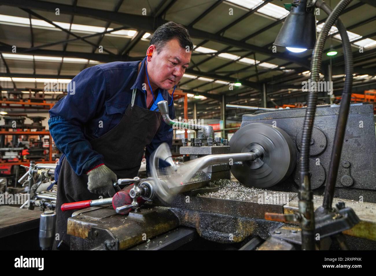 Comté de Luannan, Chine - 20 avril 2023 : les travailleurs utilisent des machines-outils pour traiter les composants de voiturettes de golf. Banque D'Images