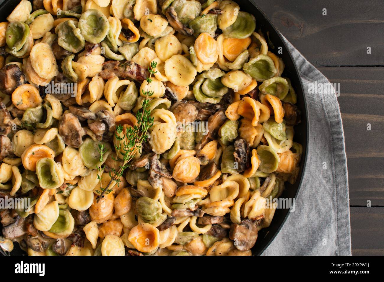 Orecchiette avec sauce au thym aux champignons dans une poêle : pâtes et champignons en sauce crème servis dans une grande sauteuse Banque D'Images