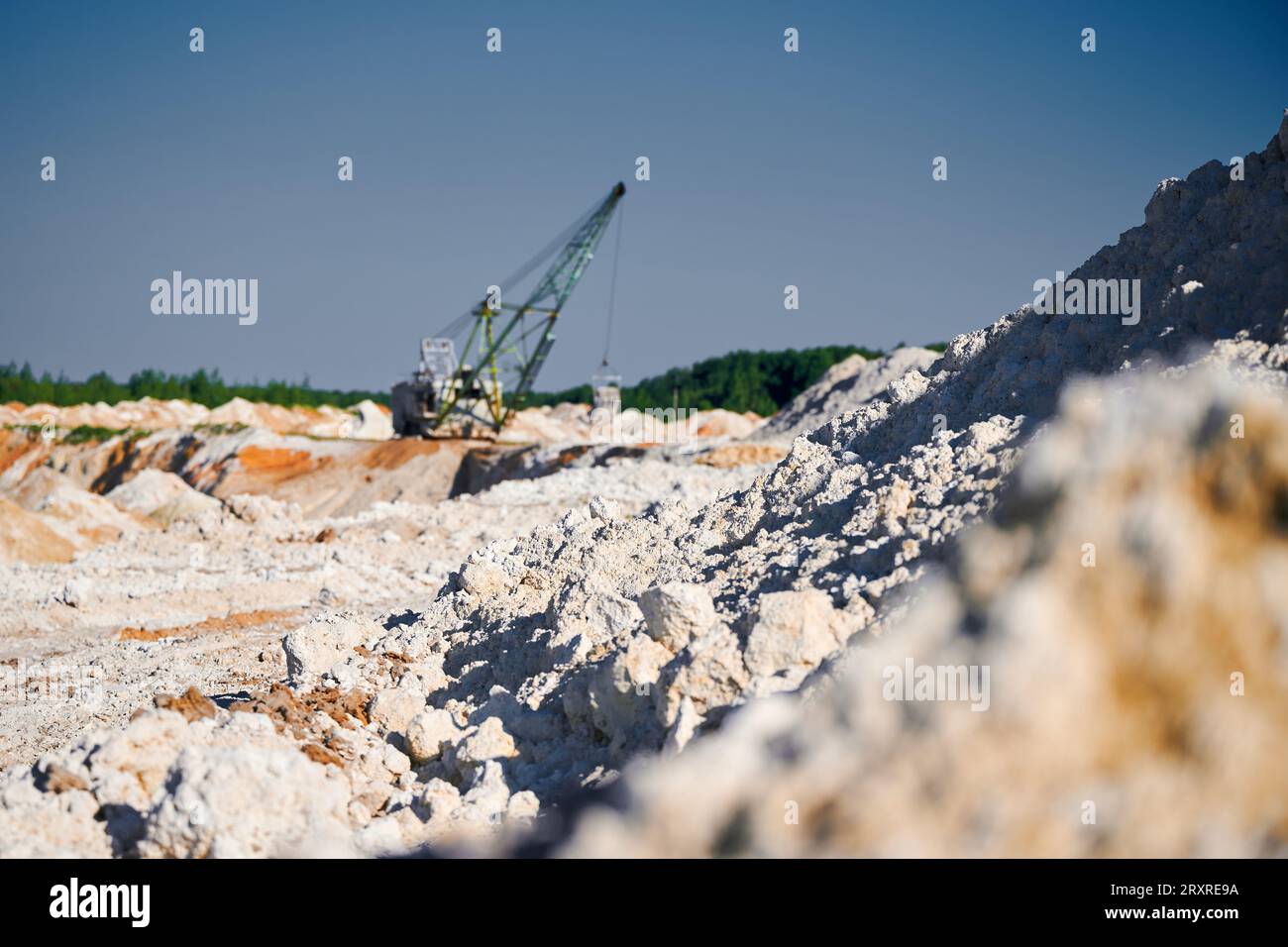 La pelle de marche fonctionne près des rangées de pieux dans la fosse minière Banque D'Images