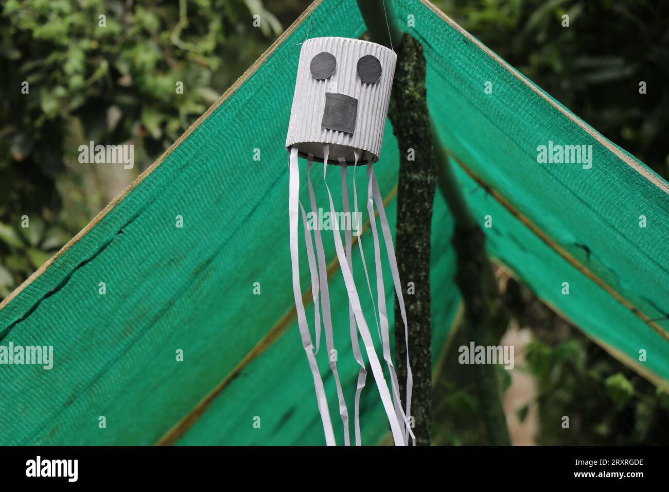 Le concept d'Halloween qui montre le fantôme fait à des fins de décoration est accroché sur un poteau avec les streamers ondulants Banque D'Images