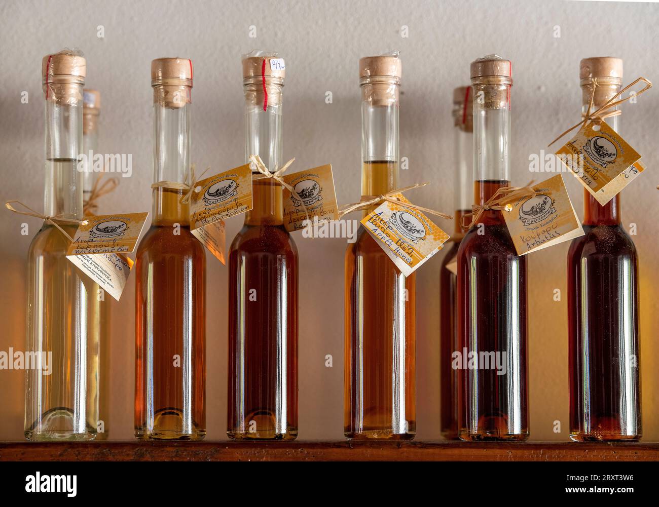 rangée de bouteilles pleines d'huiles d'olive aromatisées sur une étagère avec des étiquettes en grèce Banque D'Images