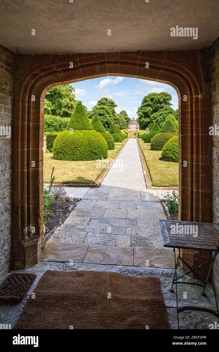 Yew Topiary dans le jardin de style Arts and Crafts vu à travers une arche à quatre centres au Lytes Cary Manor House médiéval près de Somerton, Somerton, Somerset, Angleterre Banque D'Images