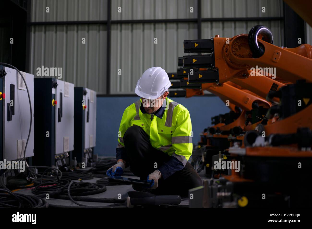 Un ingénieur travaille à l'usine de bras robotisés. Concept de technologie et d'ingénierie. Banque D'Images