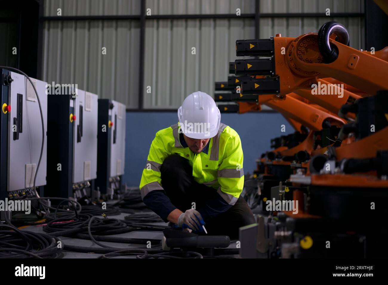 Un ingénieur travaille à l'usine de bras robotisés. Concept de technologie et d'ingénierie. Banque D'Images
