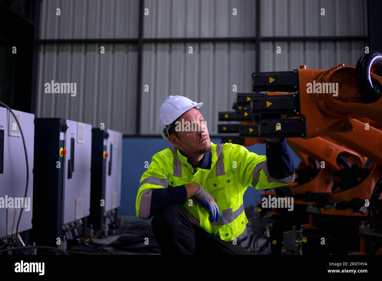 Un ingénieur travaille à l'usine de bras robotisés. Concept de technologie et d'ingénierie. Banque D'Images