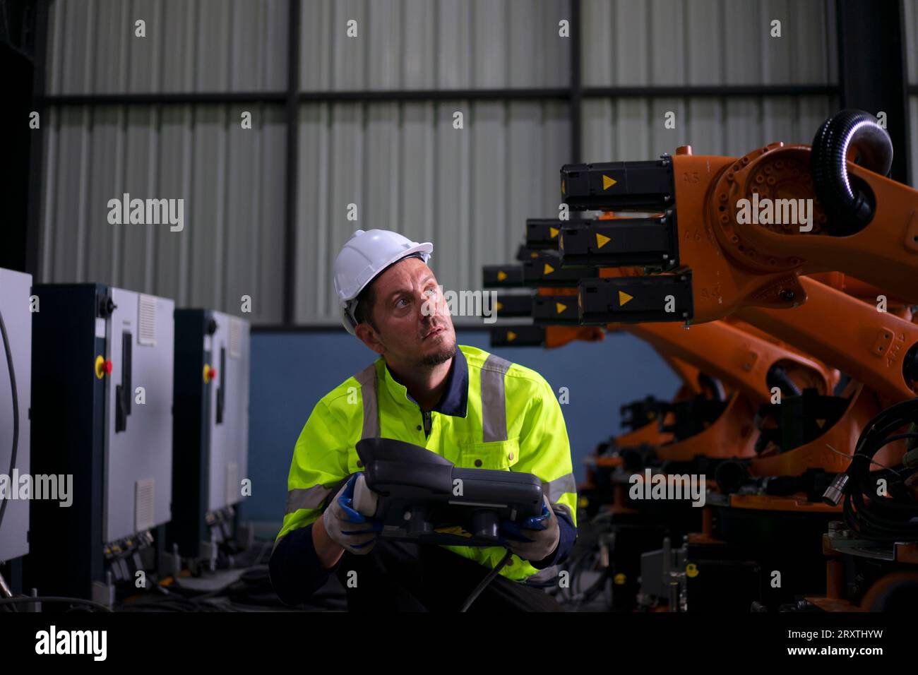 Un ingénieur travaille à l'usine de bras robotisés. Concept de technologie et d'ingénierie. Banque D'Images