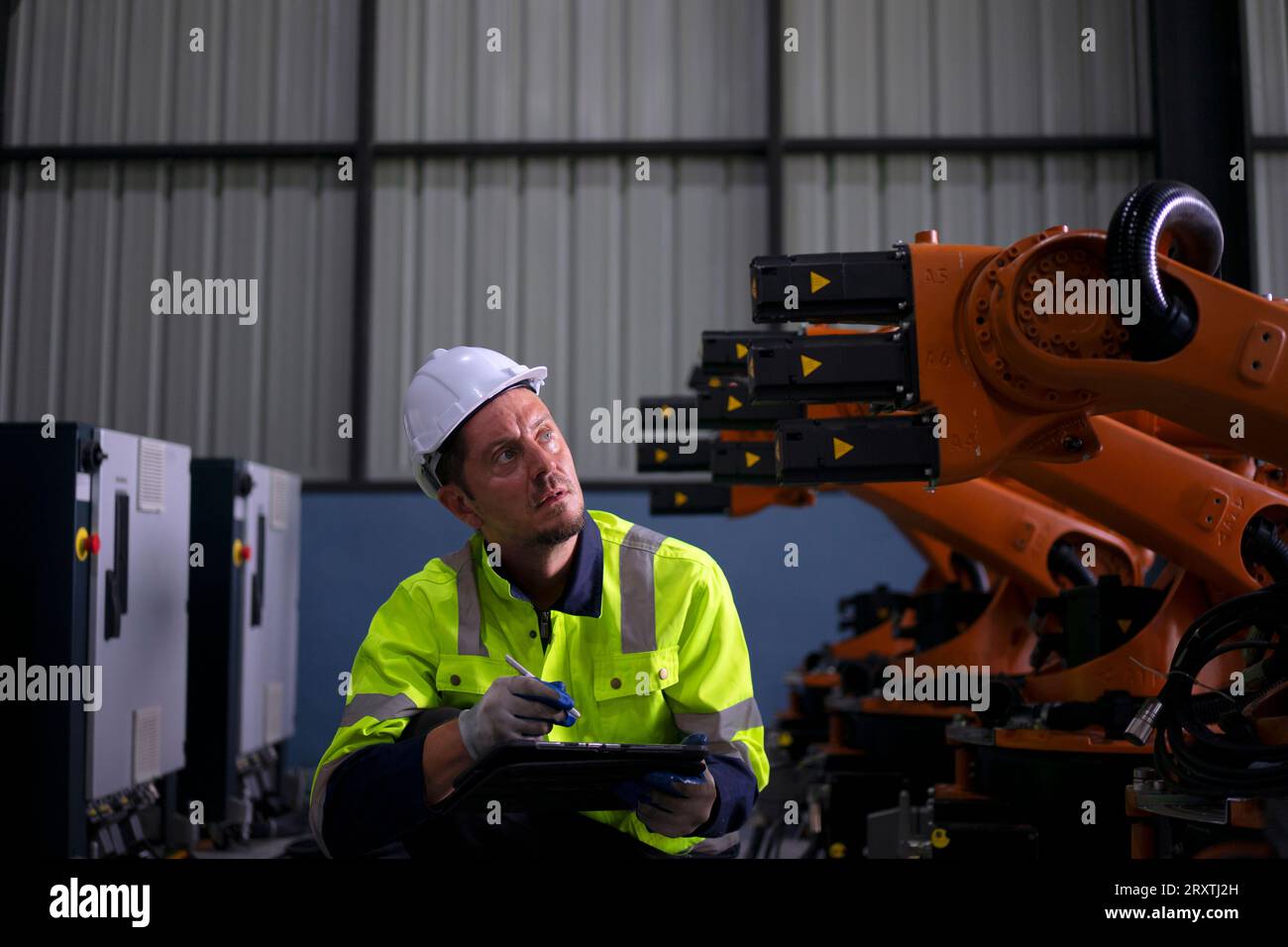 Un ingénieur travaille à l'usine de bras robotisés. Concept de technologie et d'ingénierie. Banque D'Images