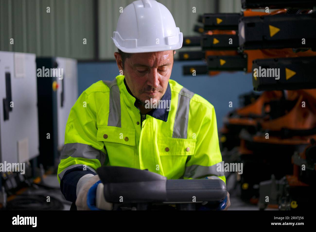 Un ingénieur travaille à l'usine de bras robotisés. Concept de technologie et d'ingénierie. Banque D'Images