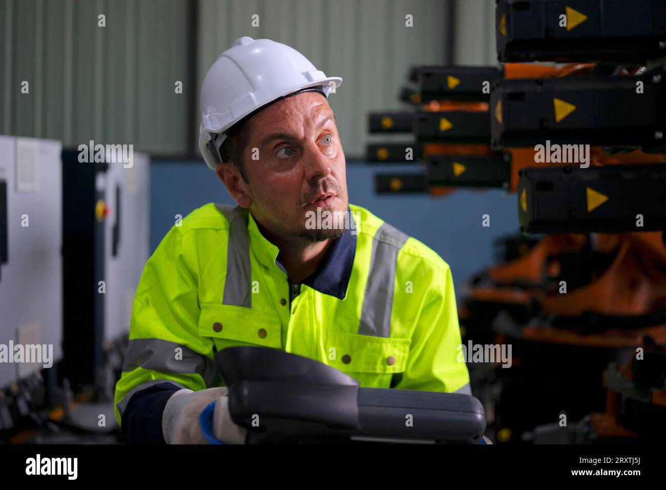 Un ingénieur travaille à l'usine de bras robotisés. Concept de technologie et d'ingénierie. Banque D'Images