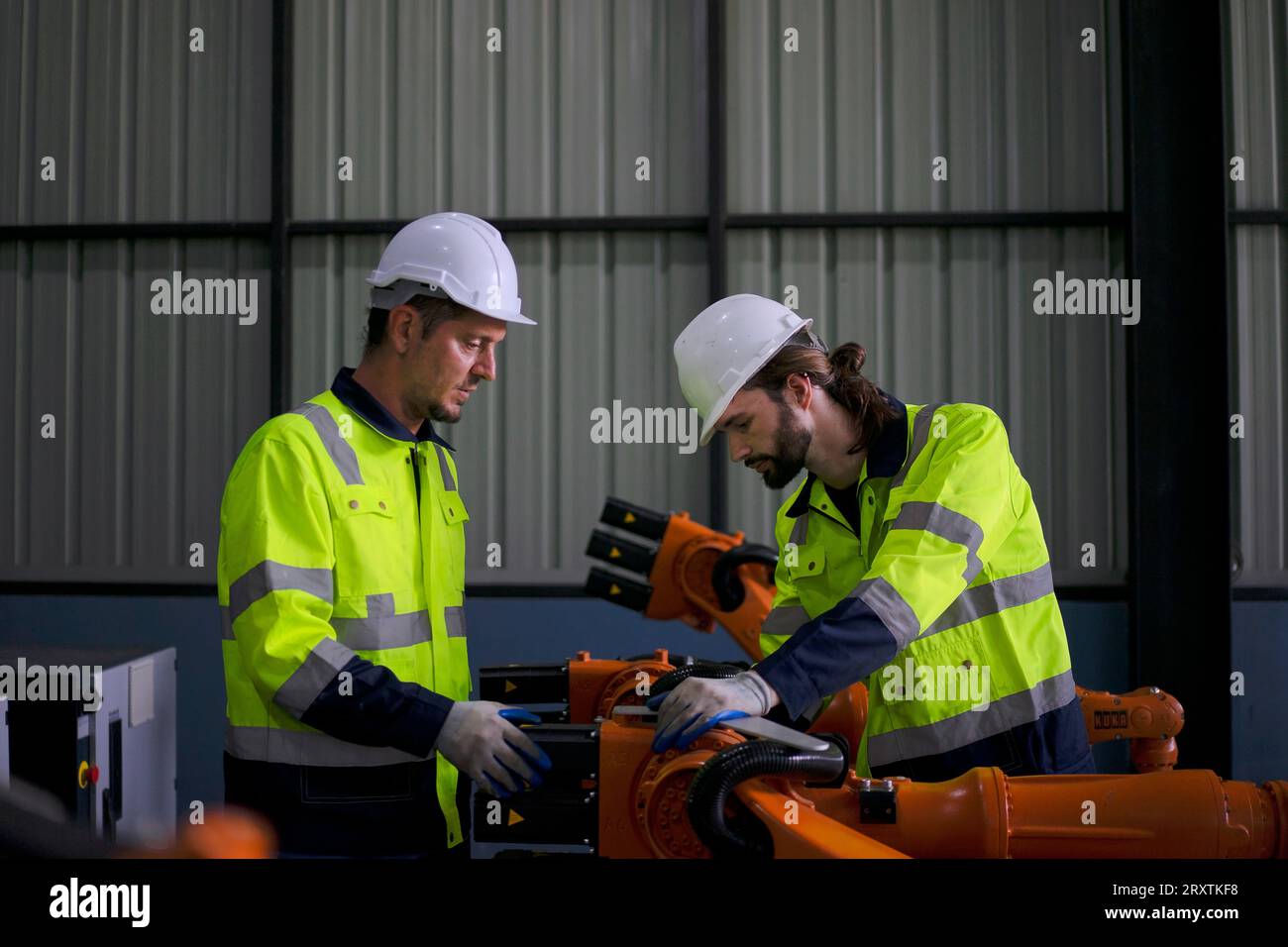 Un ingénieur travaille à l'usine de bras robotisés. Concept de technologie et d'ingénierie. Banque D'Images