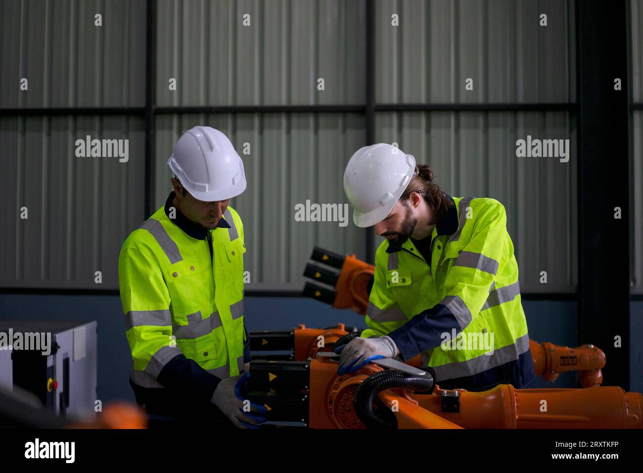 Un ingénieur travaille à l'usine de bras robotisés. Concept de technologie et d'ingénierie. Banque D'Images