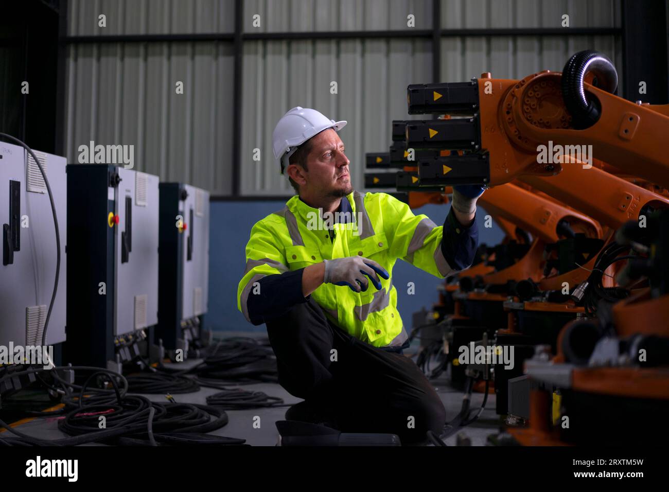 Un ingénieur travaille à l'usine de bras robotisés. Concept de technologie et d'ingénierie. Banque D'Images