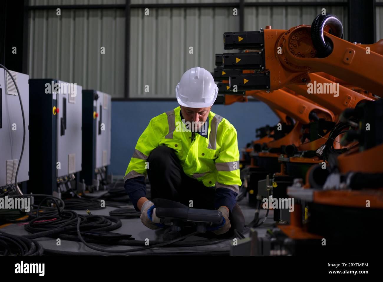 Un ingénieur travaille à l'usine de bras robotisés. Concept de technologie et d'ingénierie. Banque D'Images