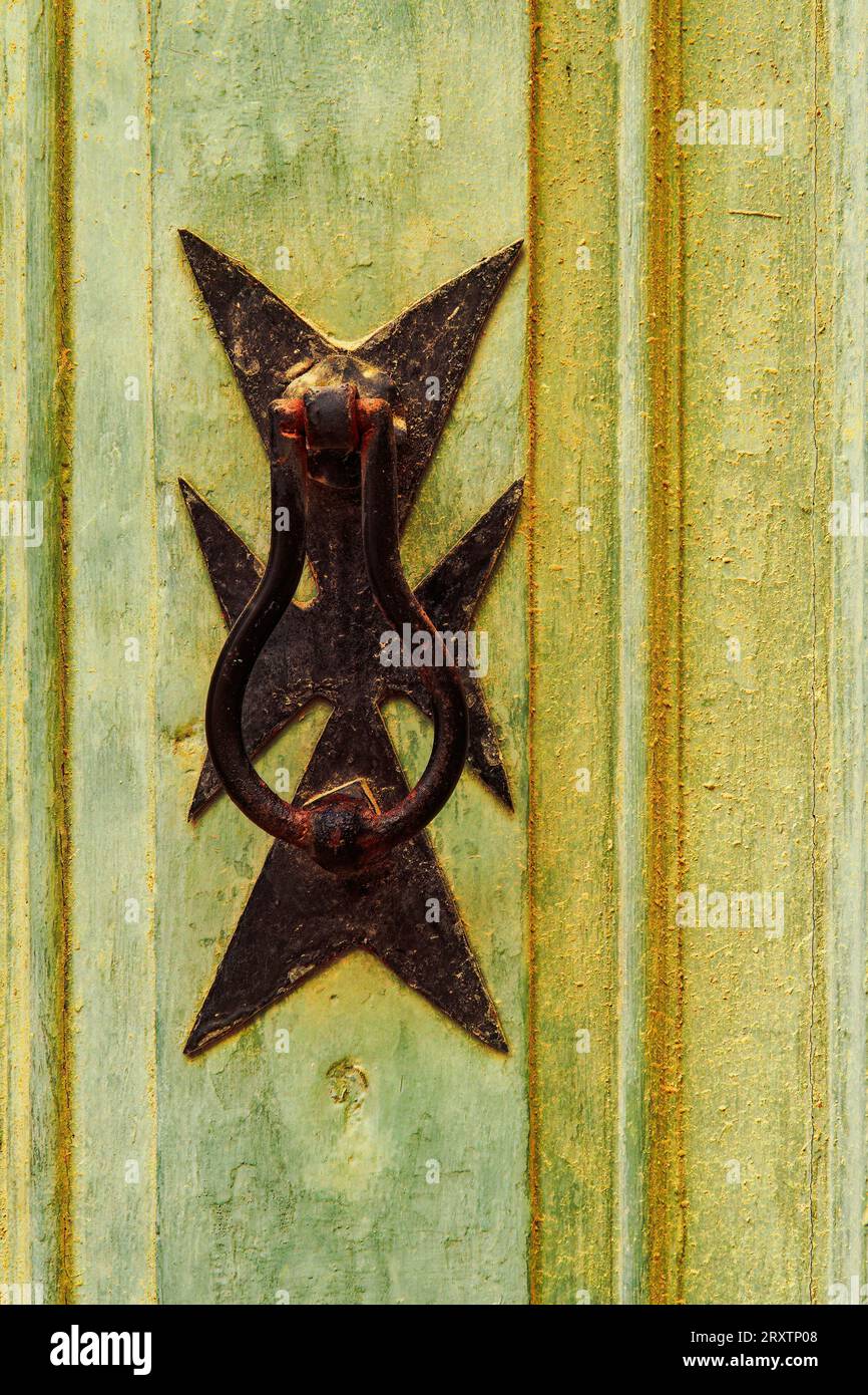 Détail de heurtoir de porte en laiton traditionnel avec la conception de croix maltaise à l'extérieur d'un bâtiment dans les ruelles de la vieille ville de Birgu (Citta Vittoriosa), Malte Banque D'Images