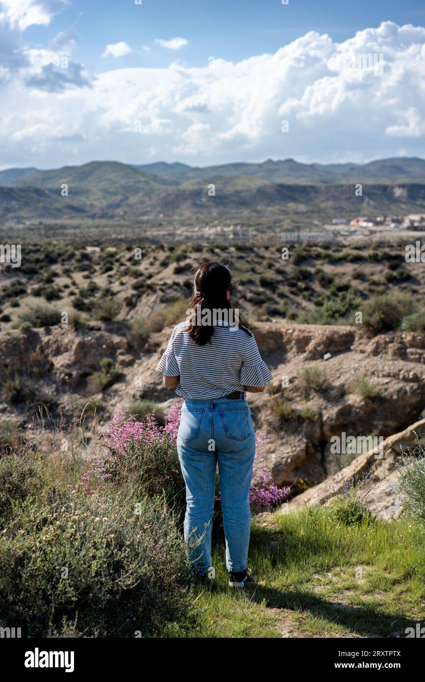 Jeune femme regardant le désert de Tabernas par une journée ensoleillée, Almeria, Andalousie, Espagne, Europe Banque D'Images