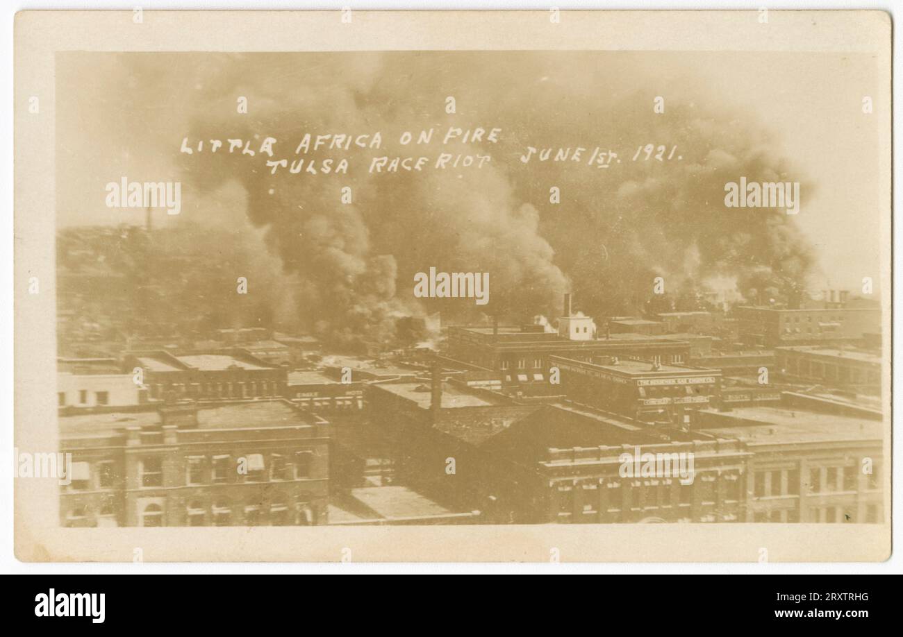 Cette carte postale photographique en noir et blanc intitulée Little Africa on Fire (Tulsa Race Riot juin 1st. 1921) représente une scène de l'émeute raciale. Il semble avoir été pris d'un endroit élevé puisque la plupart de ce que vous pouvez voir sont les toits des bâtiments, probablement industriels, puisque beaucoup ont de grandes piles de fumée et une grande quantité de fumée noire dans le ciel. Banque D'Images