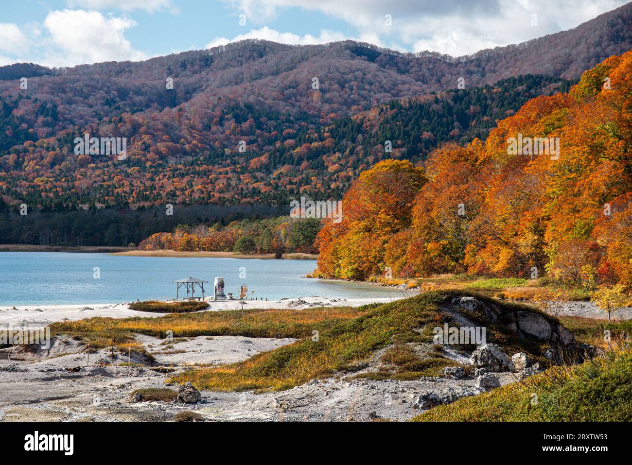 Beau paysage d'automne de feuilles rouges de feu et lac volcanique bleu doux, lac Usori au temple Osorezan Bodaiji, Mutsu, préfecture d'Aomori, Honshu Banque D'Images