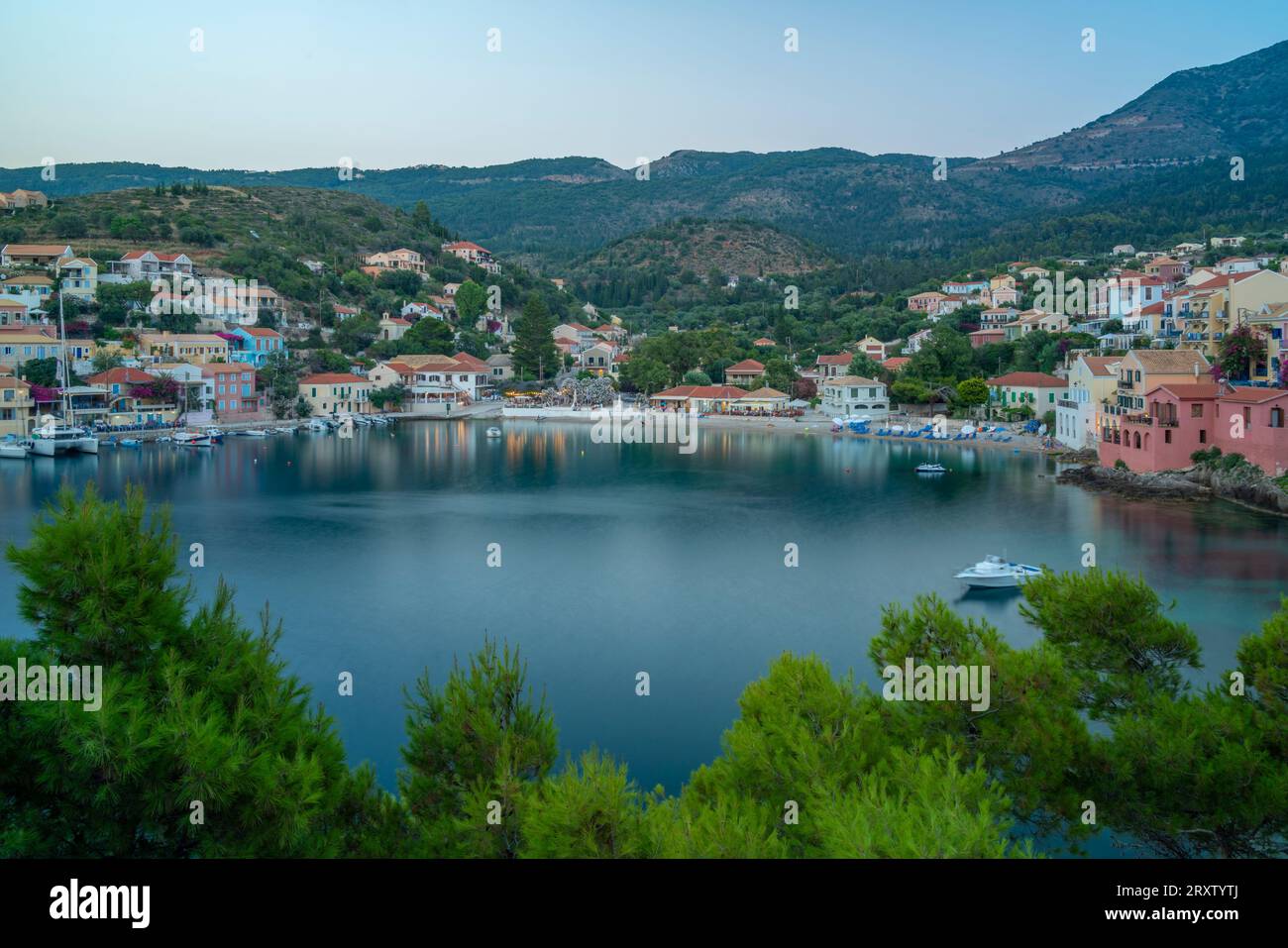 Vue élevée du port et des maisons colorées à Assos au crépuscule, Assos, Céphalonie, îles Ioniennes, îles grecques, Grèce, Europe Banque D'Images