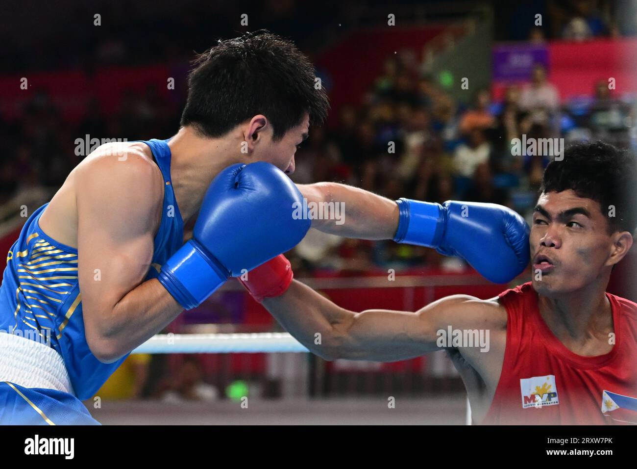Mark Ashley Fajardo (à droite) des Philippines et Xiangyang Wang de Chine (à gauche) sont vus lors de la ronde de boxe masculine de 57 16-63.5Kg des 19e Jeux asiatiques qui a lieu au gymnase de Hangzhou. Wang est le vainqueur au point 5-0. Banque D'Images