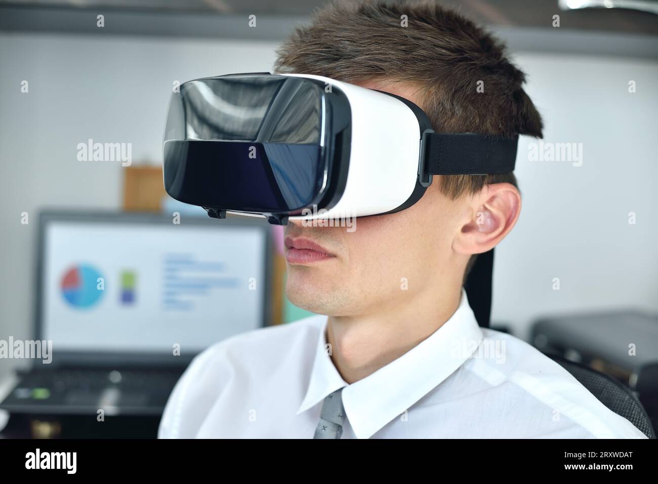 Jeune homme d'affaires avec des lunettes VR travaillant sur un rapport d'affaires virtuel. Gros plan Banque D'Images