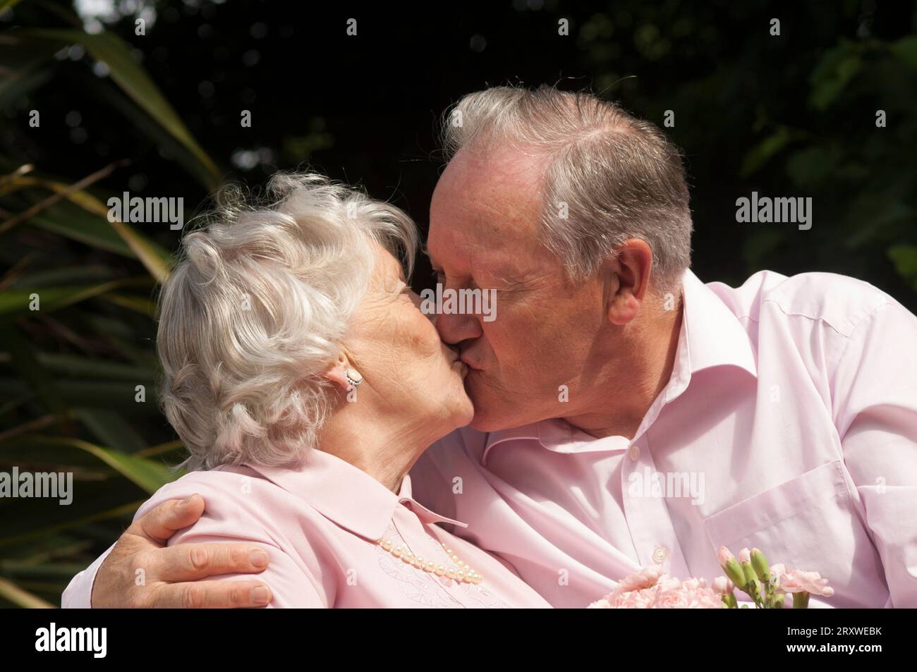 Heureux marié couple senior posant devant la caméra - John Gollop Banque D'Images