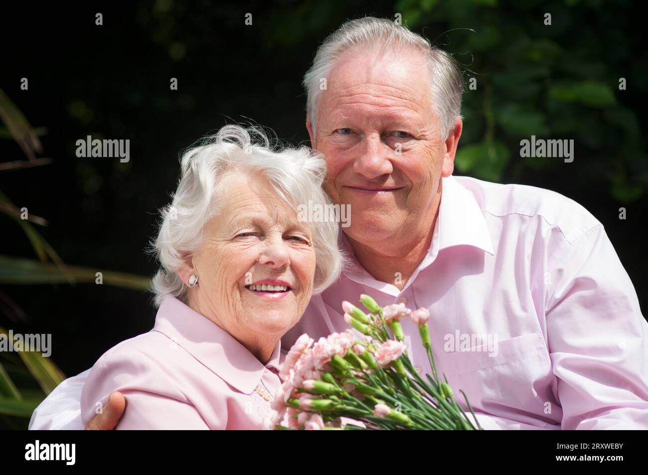 Heureux marié couple senior posant devant la caméra - John Gollop Banque D'Images