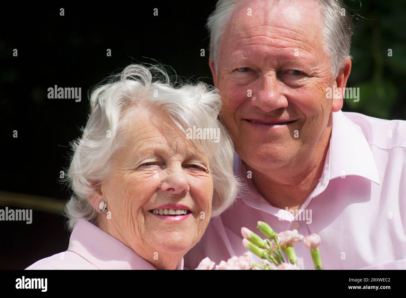 Heureux marié couple senior posant devant la caméra - John Gollop Banque D'Images