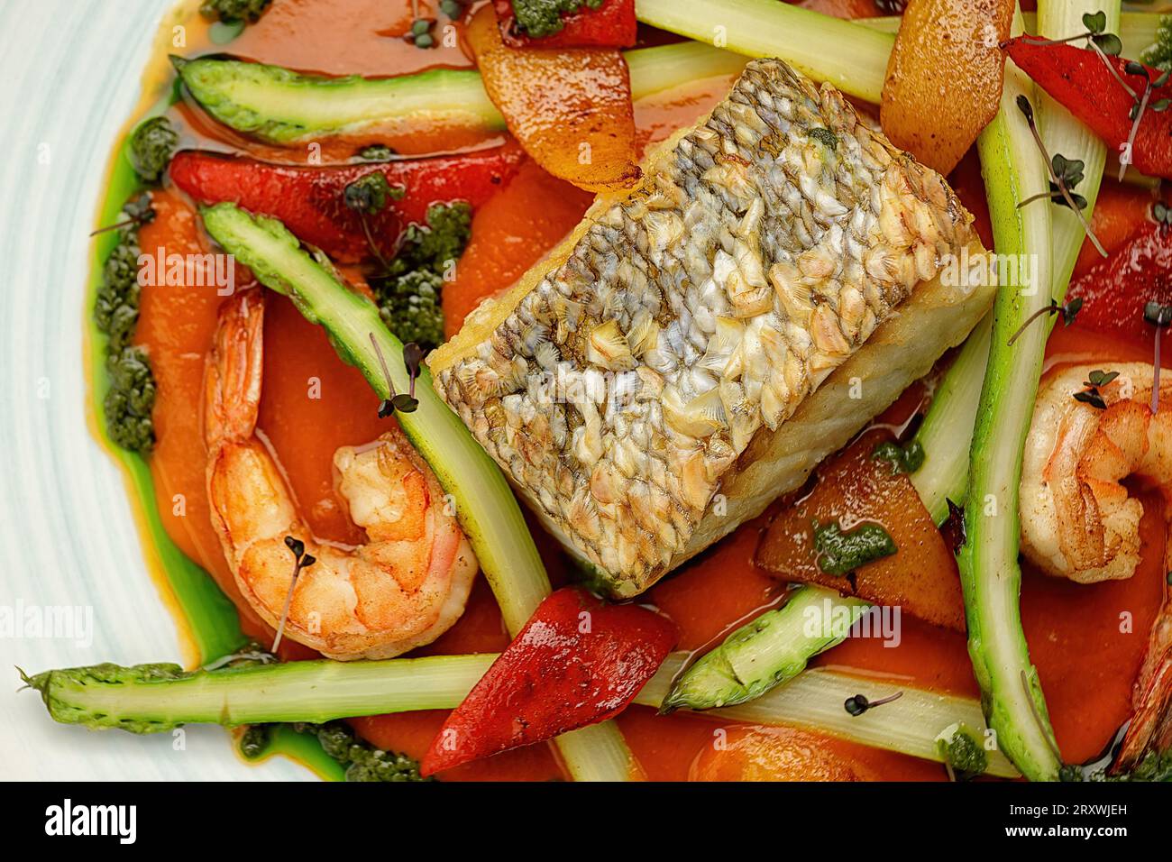 Steak de poisson frit avec crevettes et légumes sur fond sombre Banque D'Images