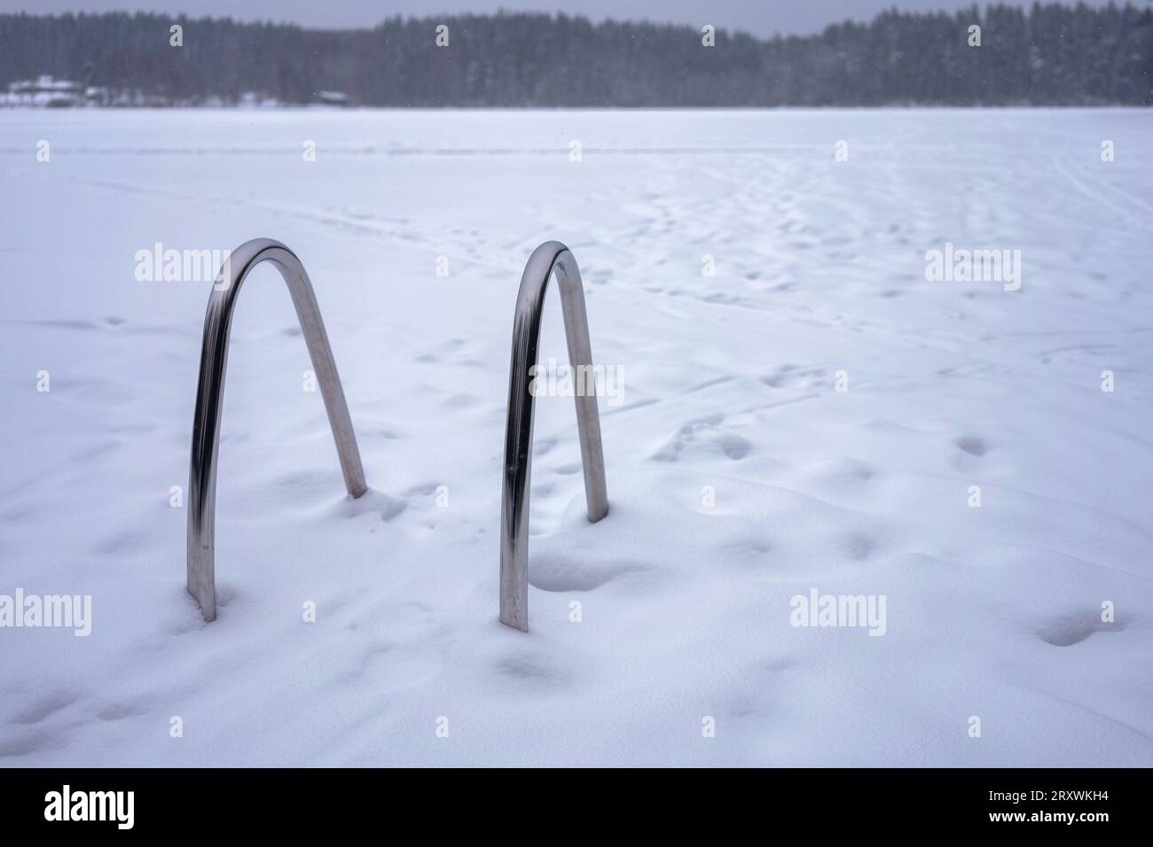 Échelle de jetée en aluminium jetant un regard sur un lac gelé à Hameenlinna, Finlande. Banque D'Images