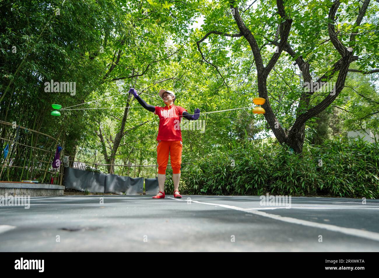 Beijing City, Chine - 22 juin 2023 : Lady jouant au diabolo dans Purple Bamboo Park, Haidian District, Beijing. Banque D'Images