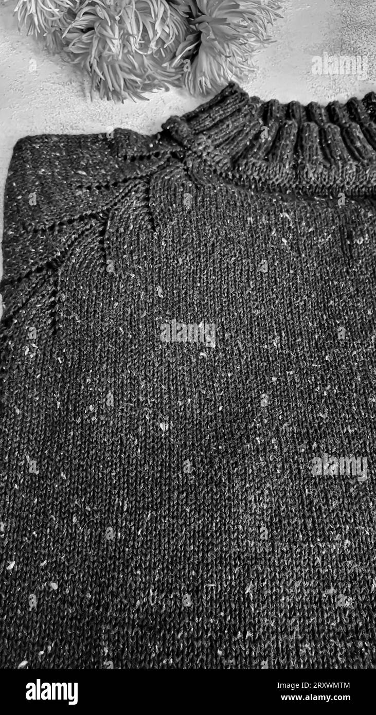 Produits tricotés faits à la main. Pull tricoté en fils de tweed. Fond gris. Espace de copie Banque D'Images
