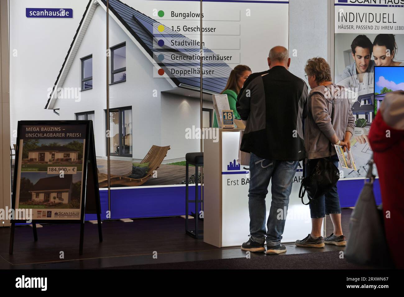 22 septembre 2023, Mecklembourg-Poméranie occidentale, Rostock : après l'ouverture du salon RoBau2023 dans le hall d'exposition, les visiteurs obtiennent des informations auprès d'un fournisseur de maisons préfabriquées. Les matières premières renouvelables prennent un grand espace dans la plus grande foire de la construction dans l'état du 22-24.09.2023. Photo : Bernd Wüstneck/dpa Banque D'Images