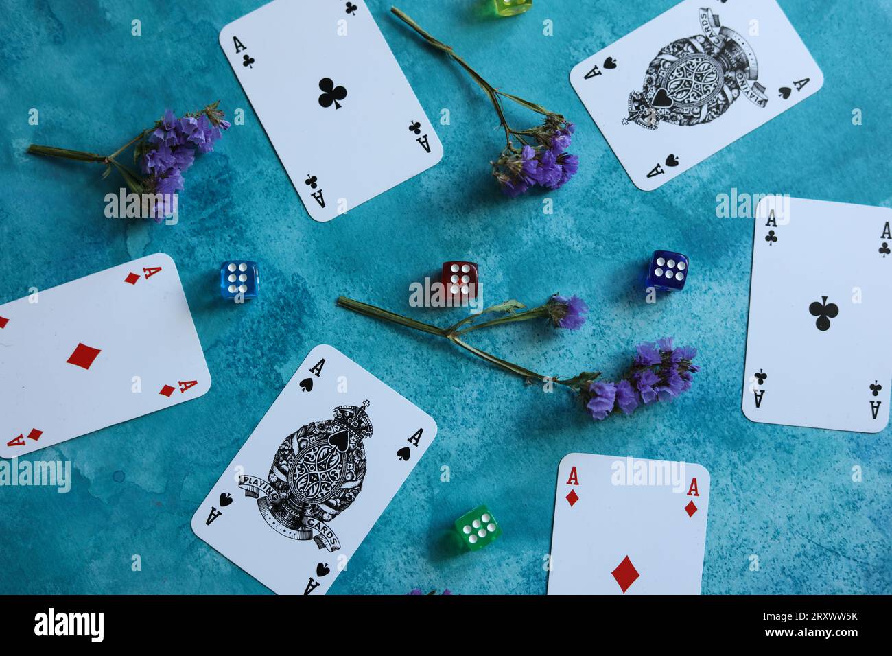 motif avec des cartes à jouer, des dés colorés et des fleurs sèches statice sur fond aquarelle bleu Banque D'Images