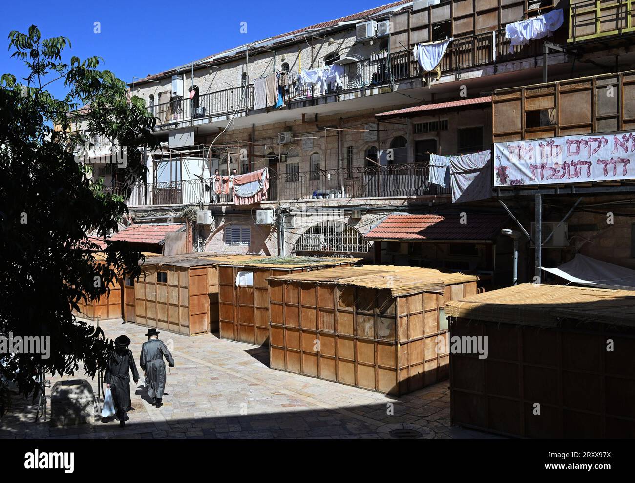 Les Juifs ultra-orthodoxes passent devant des huttes temporaires en bois, les sukkahs, utilisées pendant la fête juive de Soukcot, la fête des Tabernacles, à Mea Shearim à Jérusalem, le mercredi 27 septembre 2023. Les Juifs religieux construisent des sukkahs, pour commémorer les 40 ans que les Israélites ont erré dans le désert après leur exode d'Egypte. Photo de Debbie Hill/ UPI Banque D'Images