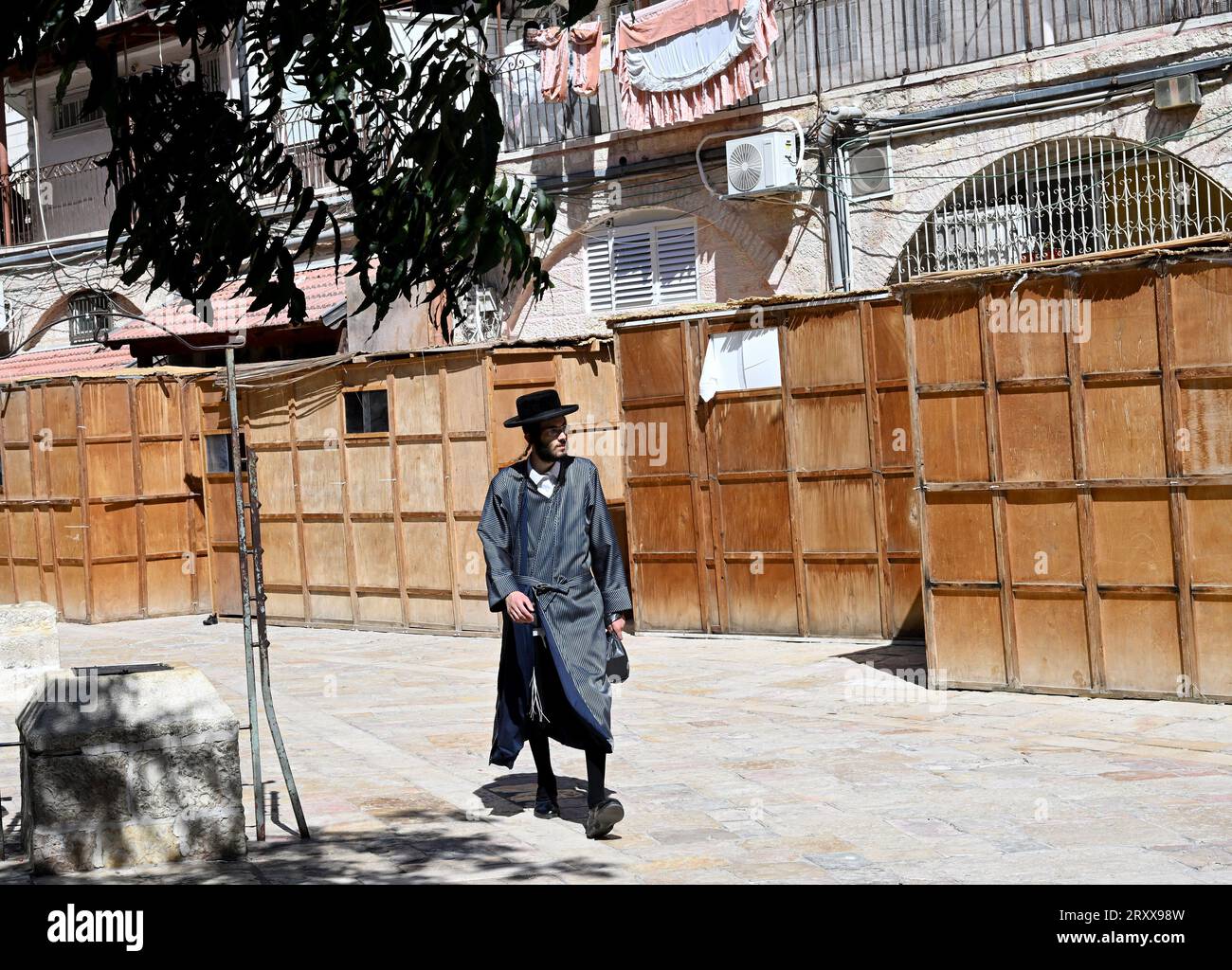 Un juif ultra-orthodoxe passe devant des huttes temporaires en bois, des sukkahs, utilisées pendant la fête juive de Soukcot, la fête des Tabernacles, à Mea Shearim à Jérusalem, le mercredi 27 septembre 2023. Les Juifs religieux construisent des sukkahs, pour commémorer les 40 ans que les Israélites ont erré dans le désert après leur exode d'Egypte. Photo de Debbie Hill/ UPI Banque D'Images