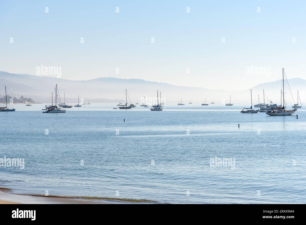 Bateaux alants ancrés dans une baie enveloppée dans le brouillard matinal en automne Banque D'Images