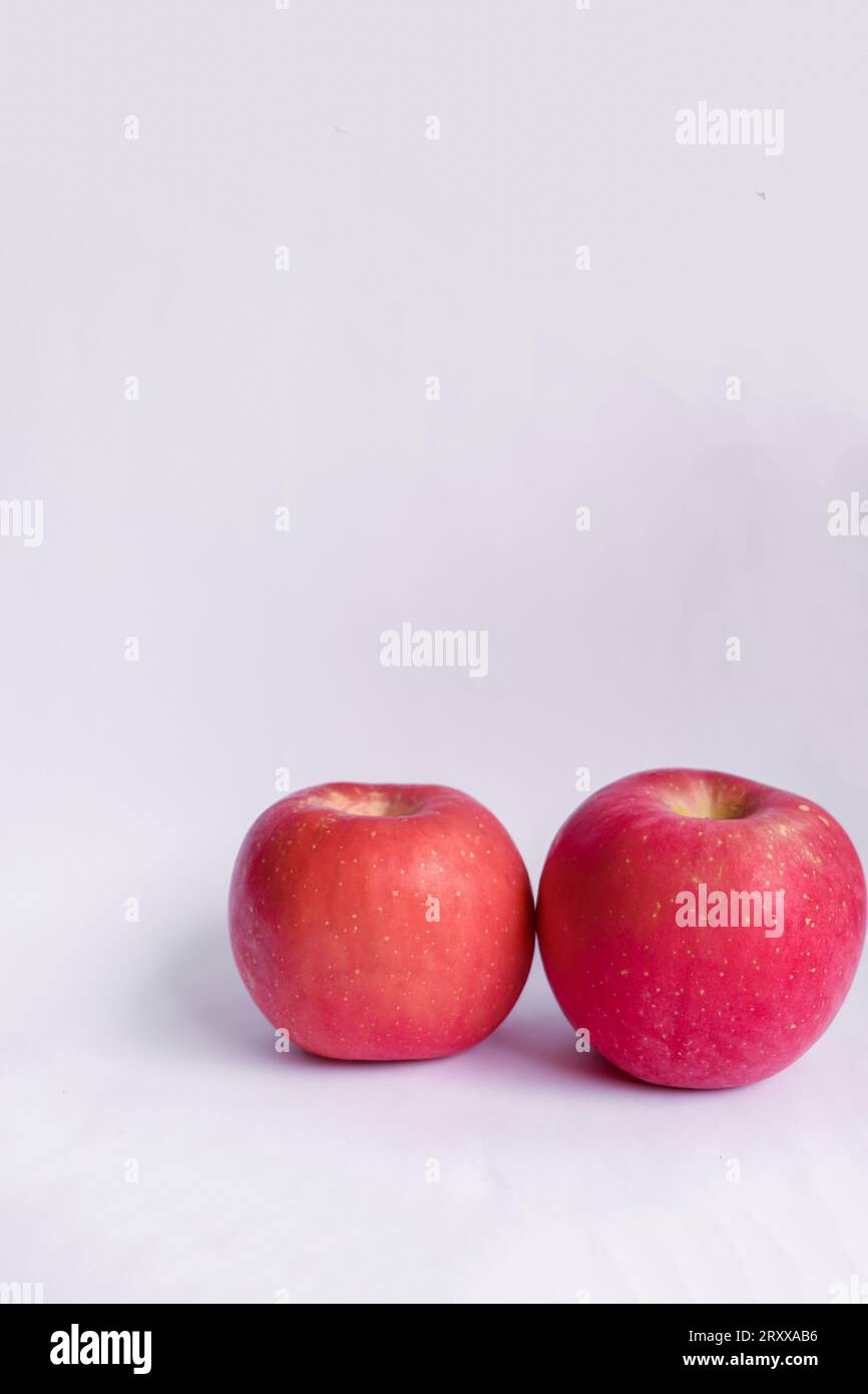 Deux pommes Fuji rouges sur fond isolé blanc Banque D'Images