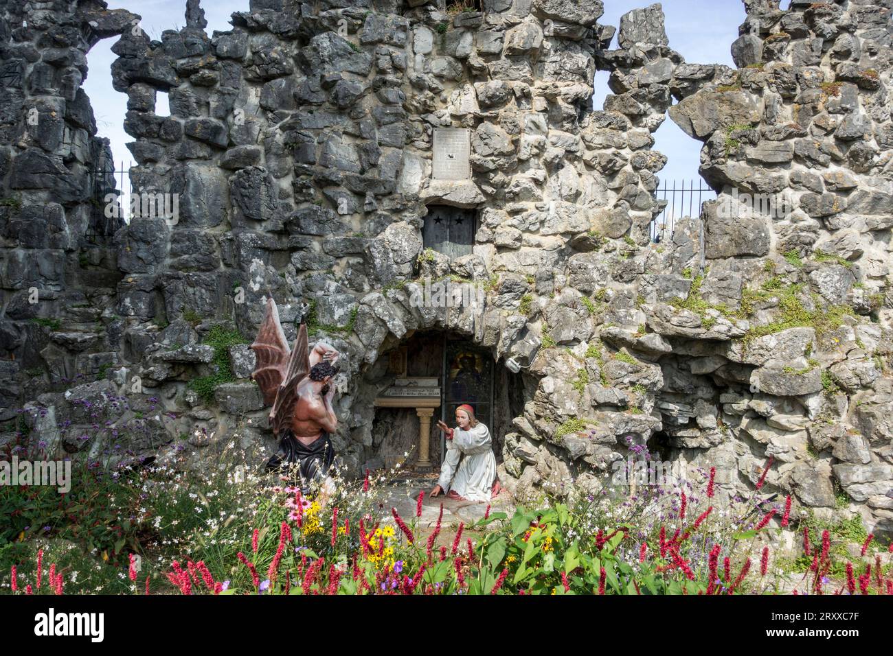 Sculpture du diable et Saint Antoine de Padoue à la grotte dans le village Crupet, Assesse, province de Namur, Ardennes belges, Wallonie, Belgique Banque D'Images