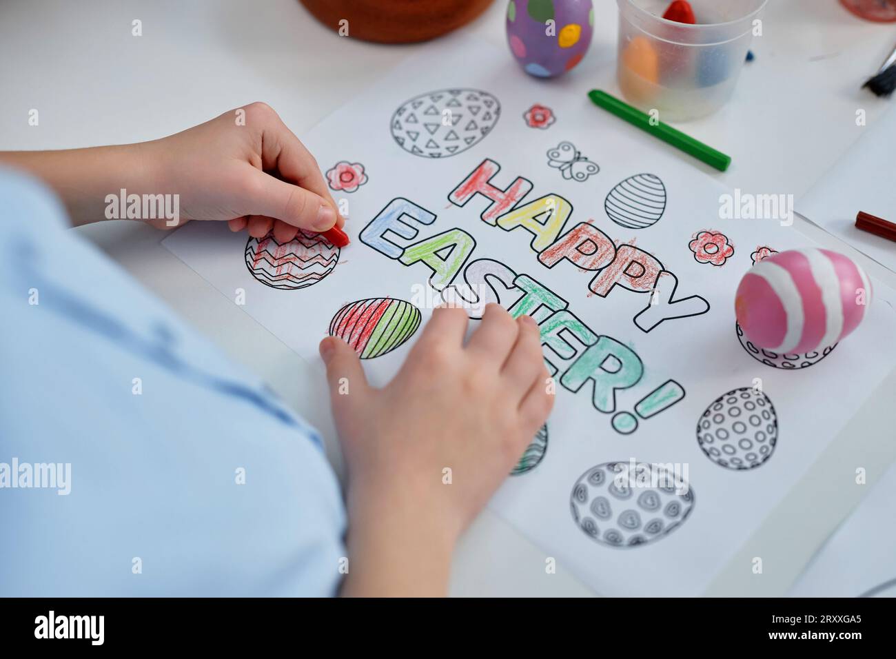 Gros plan de l'enfant méconnaissable coloriage carte de Pâques joyeuse dans la maternelle tout en célébrant les vacances de printemps, espace de copie Banque D'Images