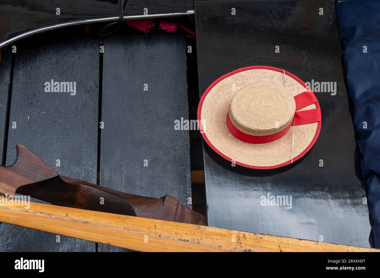 Le chapeau de paille traditionnel d'un gondolier vénitien appelé canotier vénitien ou plaisancier, avec une bande de ruban rouge, et pend librement à l'arrière, sur bo Banque D'Images