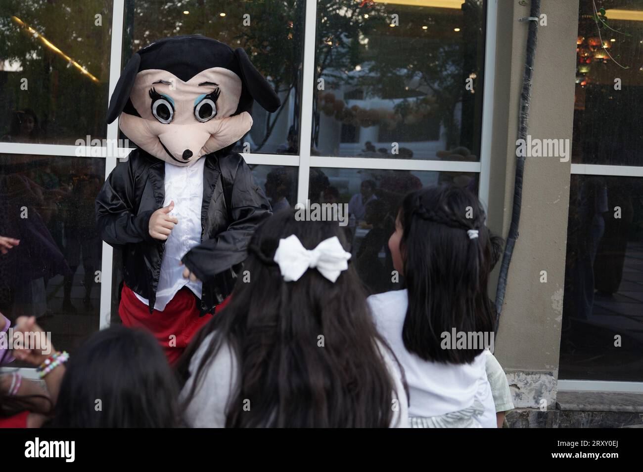 Clown de fête ou personnage jouant avec les enfants. fête d'anniversaire en plein air pour enfants. Les enfants jouant avec le clown. les enfants jouent avec la personne qui porte la souris micky Banque D'Images