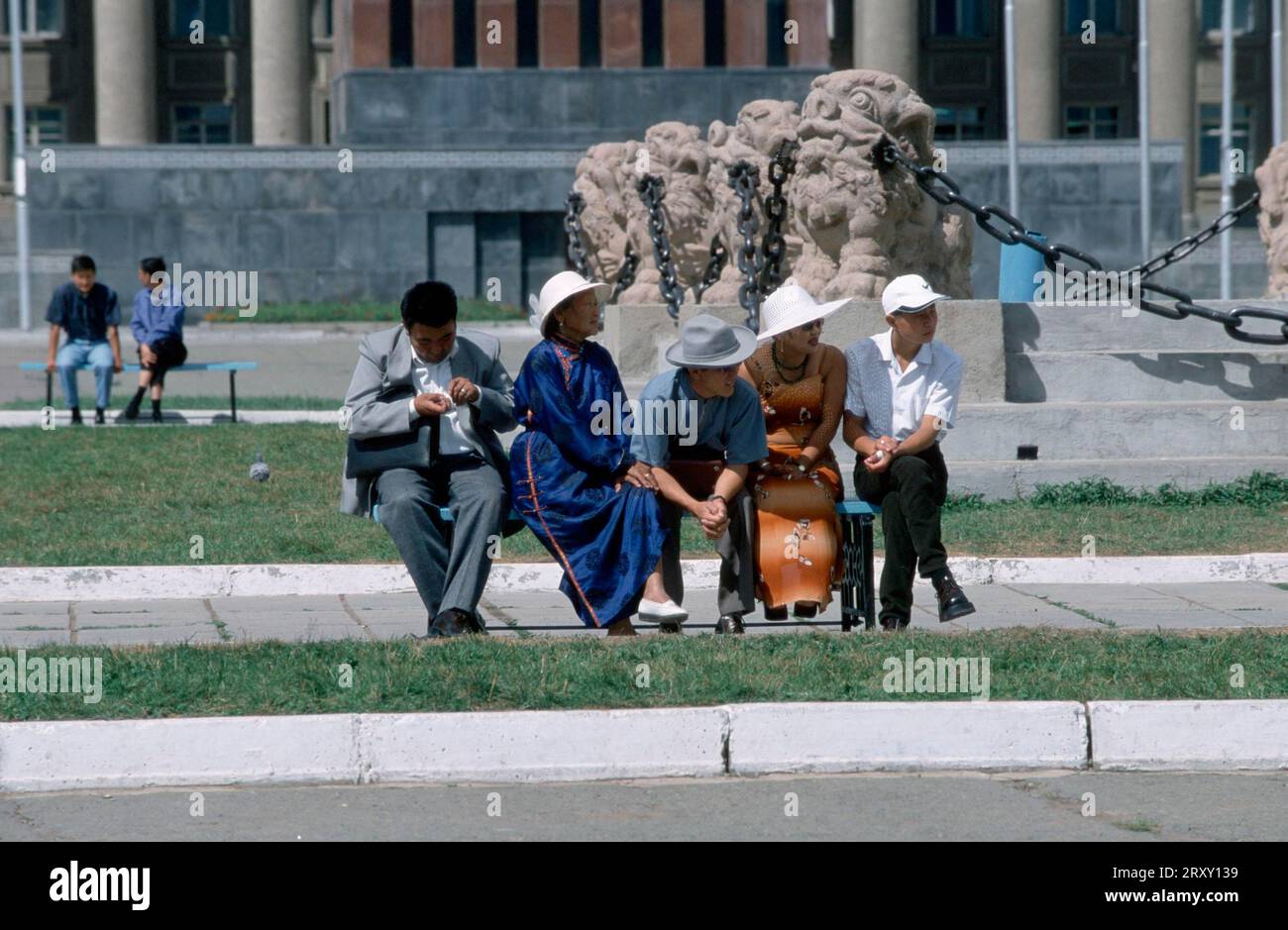 Les gens assis sur un banc, place Sukhbaatar, place principale de la ville, Oulan Baatar, Mongolie Banque D'Images