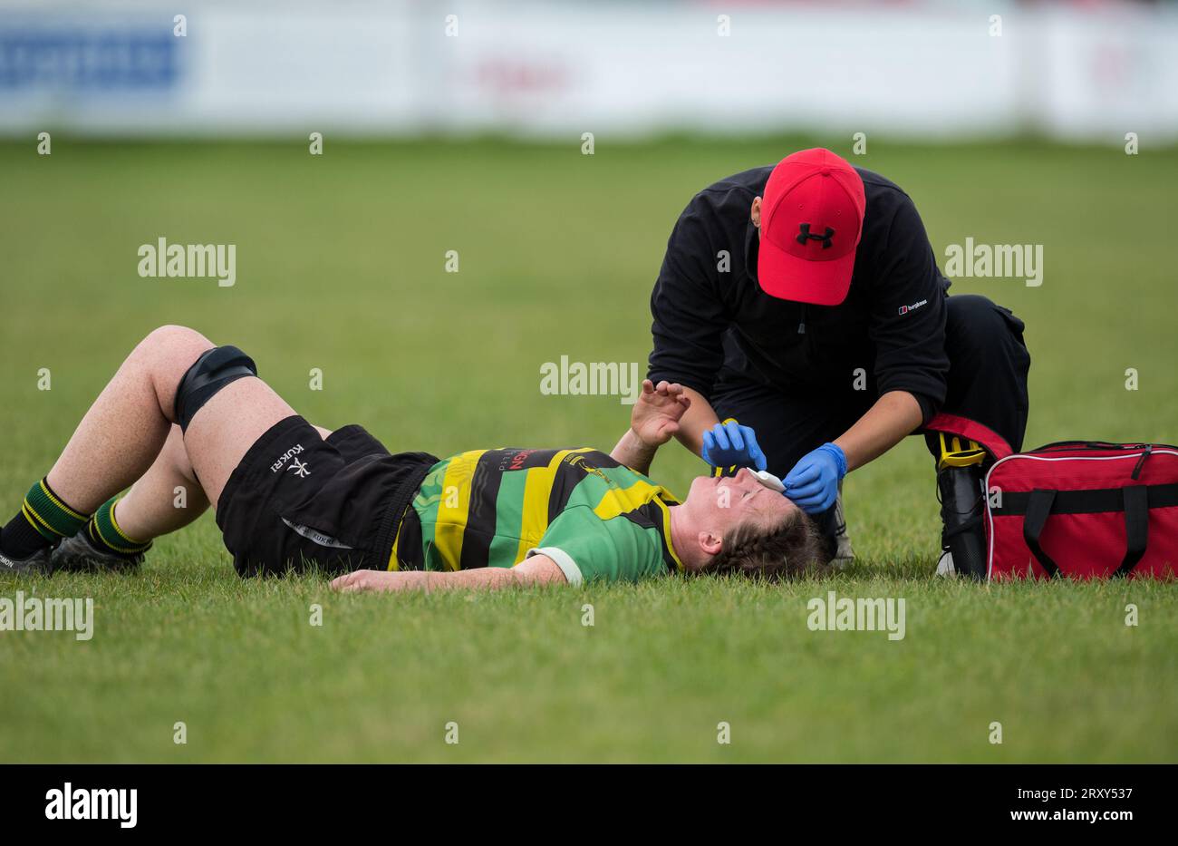 Joueuse amateur anglaise de Rugby Union recevant des soins de premiers secours tout en jouant dans un match de ligue. Banque D'Images