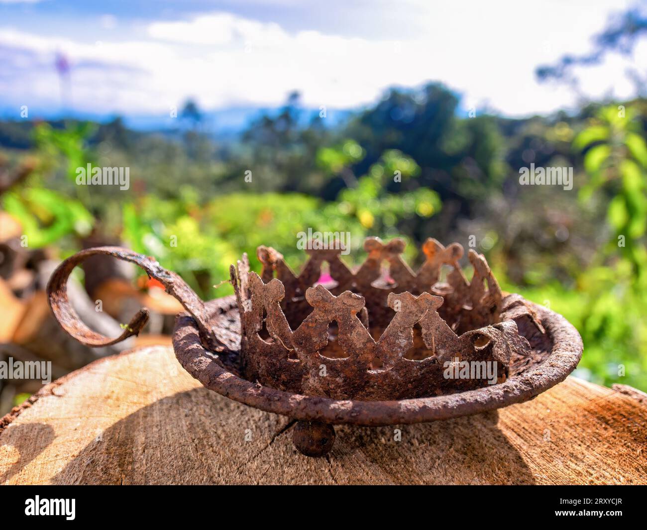 Photographie rapprochée d'un vieux chandelier en étain rouillé et patiné, trouvé dans la terre, contre le paysage d'une ferme près de la ville d'Arcabuco. Banque D'Images