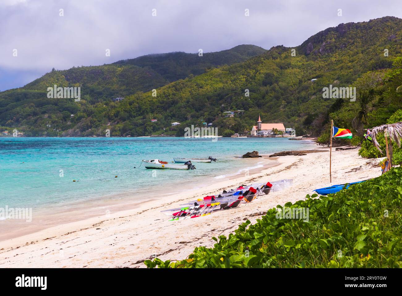 Paysage d'été de plage d'Anse Royale avec kayaks en plastique transparent à louer et drapeau des Seychelles par une journée ensoleillée Banque D'Images