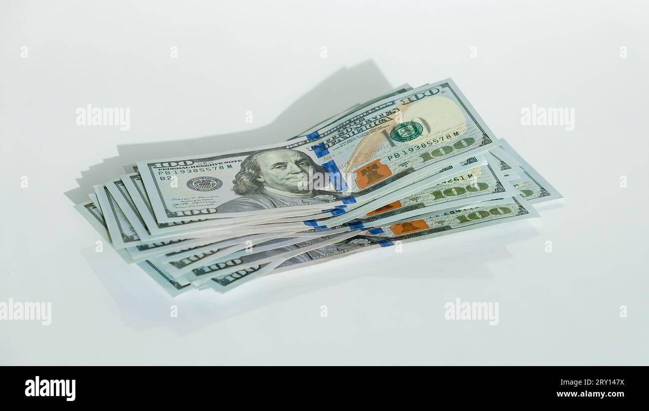 Pile de billets de cent dollars sur fond blanc gros plan look. Finance et concept d'affaires. Photo de haute qualité Banque D'Images