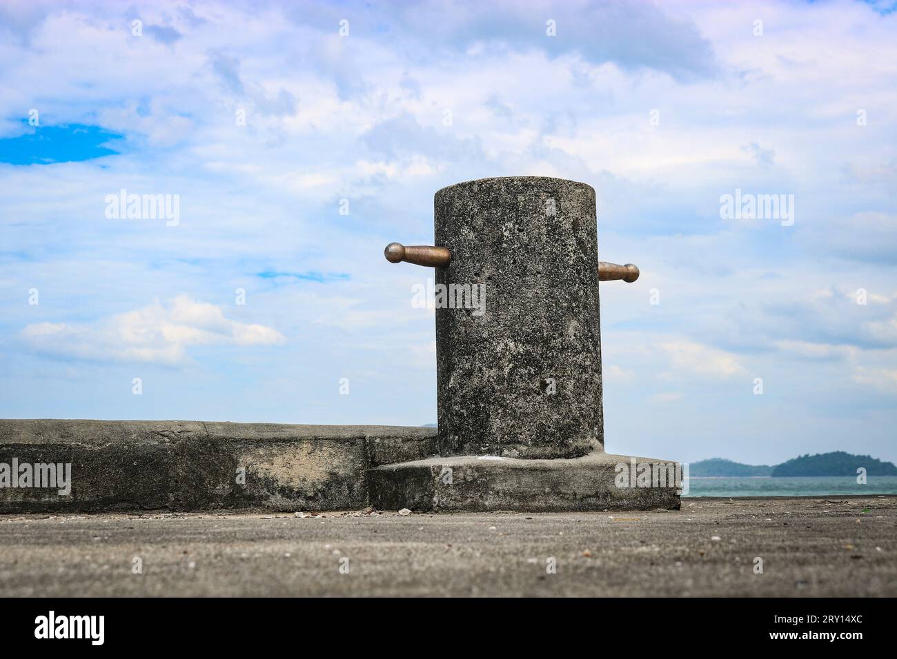 Pilier en béton pour amarrer des navires sur une jetée. Bollard contre le ciel bleu. Banque D'Images