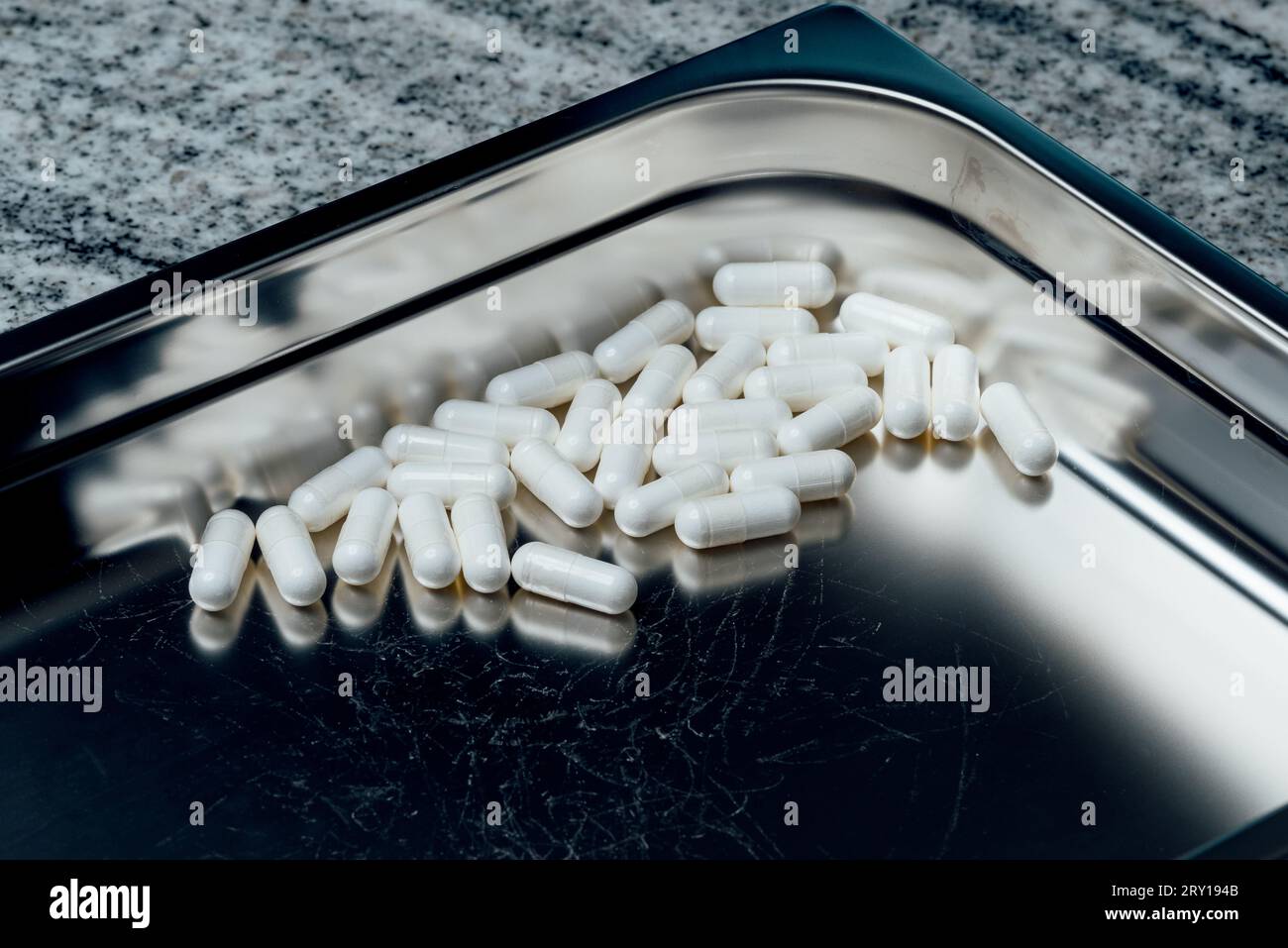 pilules et vitamines sur un plateau en acier inoxydable Banque D'Images
