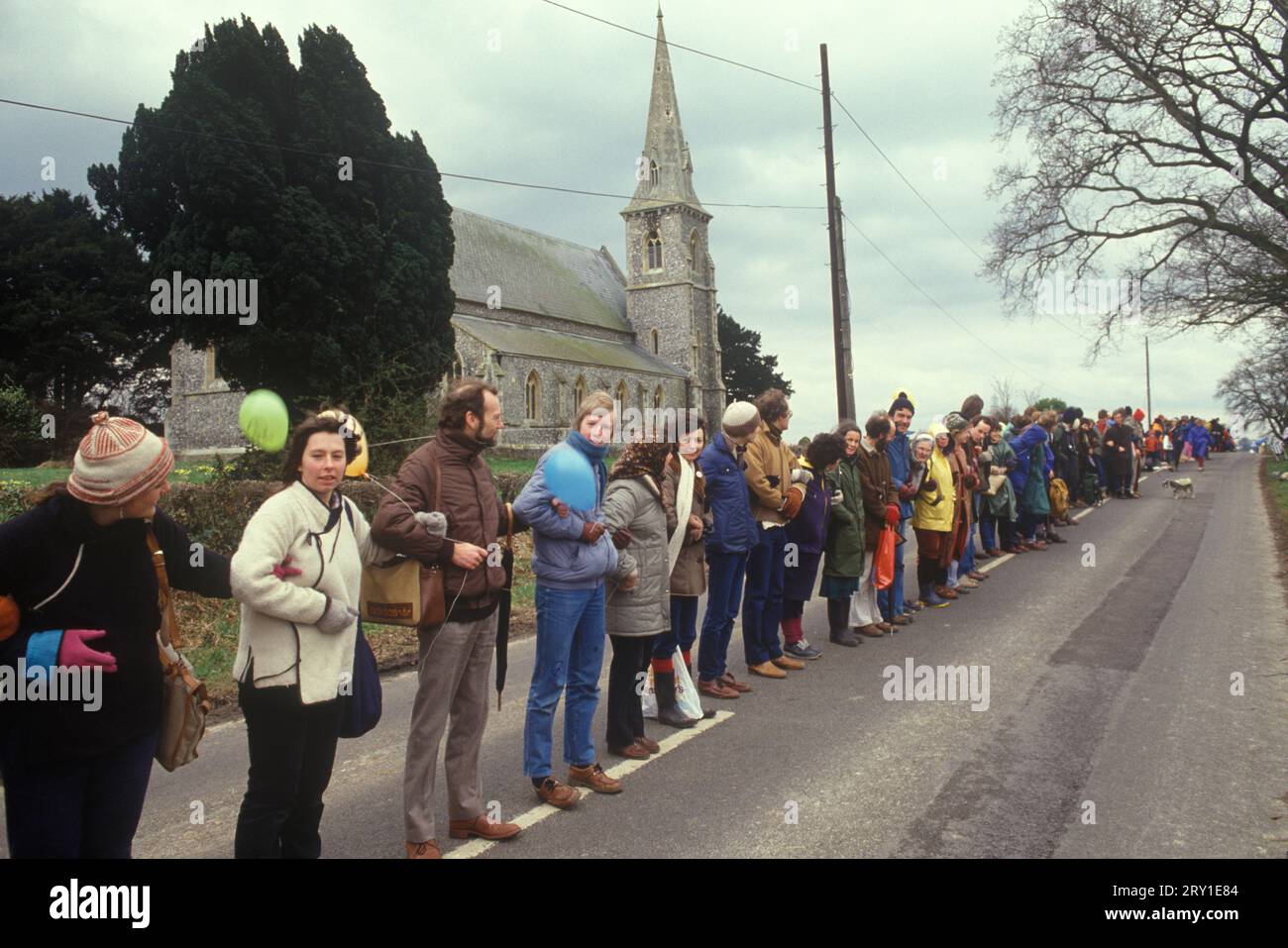 Protestation avec les armes liées. Aldermaston à Greenham Common vendredi Saint Pâques 1983. Les manifestants pour la paix formaient une chaîne humaine s'étendant sur 14 miles. Ils ont tracé une route le long de ce que les manifestants appellent la "Nuclear Valley" dans le Berkshire. La chaîne a commencé à la base aérienne américaine de Greenham Common, a dépassé le centre de recherche nucléaire d'Aldermaston et s'est terminée à l'usine de munitions de Burghfield. ANNÉES 1980 ROYAUME-UNI HOMER SYKES Banque D'Images